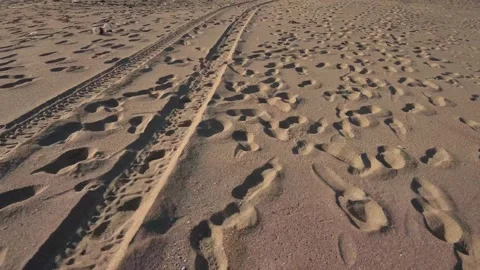 Walking on sandy beach with human footprints and jeep tyre tracks Stock Footage 201536721