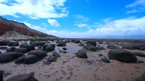 Walking on a sandy beach with rocks by Hunstanton Cliffs Stock Footage 120114529