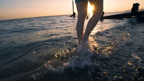 Walking by the sea at sunset, slow motion Stock Footage 76887498