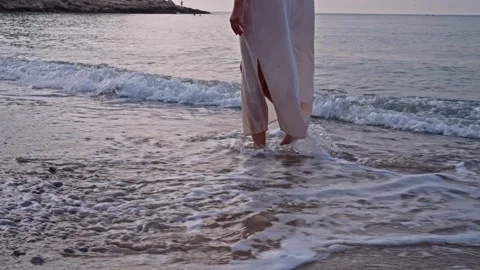 Walking in the shallow water at the beach during sunset Видео 342786614