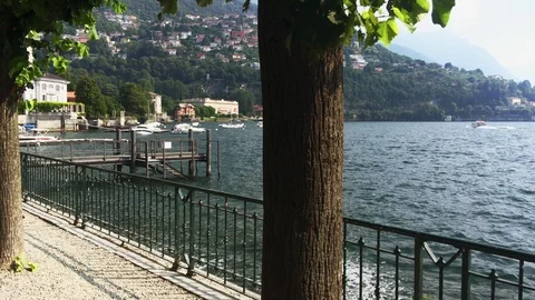 Walking on the shore of Como lake in the tree-lined avenue Stock Footage 118650128