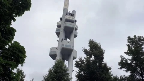 A walking shot down a tree looking up with the Zizkov tower in the distance. Video stock 168700266