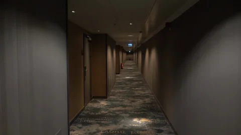 Walking slowly down empty dark hotel corridor Stock Footage 119881191