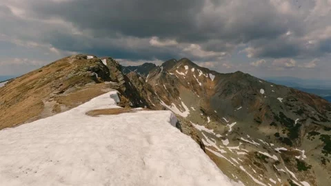 Walking on Snow Drift Along Spring Mountain Ridge in the Alps Landscape Stock Footage 322802481