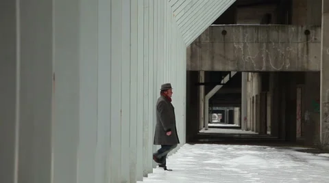Walking on snow of man with the hat, coat scarf in an abandoned urban building Stock Footage 48022073
