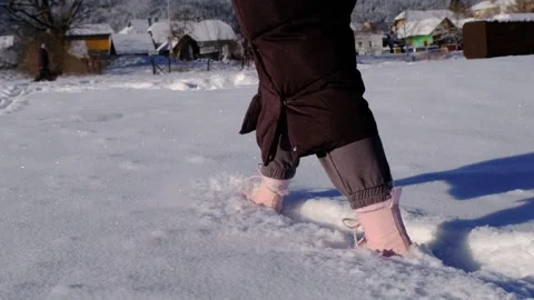 Walking in the snow in slow motion. Close-up of feet walking in the snow in slow Stock Footage 263148913