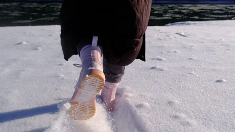 Walking in the snow in slow motion. Close-up of feet walking in the snow in slow Stock Footage 264949459