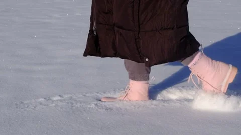 Walking in the snow in slow motion. Close-up of feet walking in the snow in slow Stock Footage 275243732