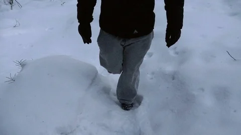 Walking in a snowy forest, Slow motion view following a young males feet, hik Stock Footage 86746675