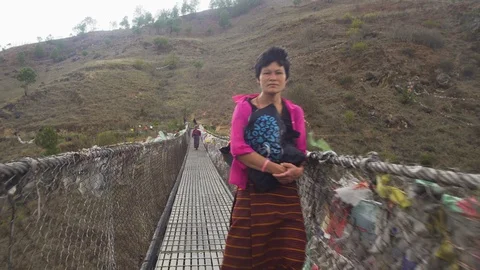 Walking in a suspension bridge in Himalayas with local people crossing. Stock Footage 100722366