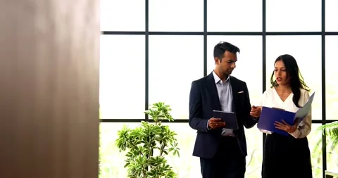 Walking with tablet inside office, Indian businessman discuss project at window Stock Footage 342593524