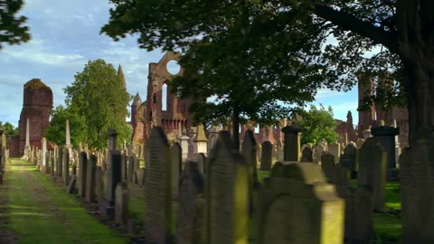 Walking through an ancient cemetery with abbey ruins in Scotland Stock Footage 336778767