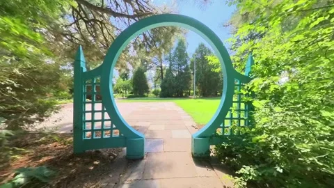 Walking through the blue circular arch gate in the Cheyenne Botanic Gardens 库存影片 264796848