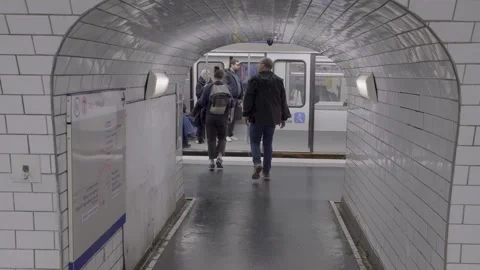 Walking through a busy Paris subway station towards the train, capturing urban Stock Footage 305473480
