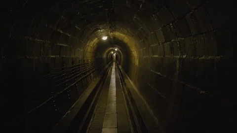 Walking through dimly lit underground tunnel with arched walls Stock-Footage 301150414