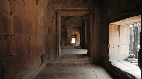 Walking through enigmatic stone corridor within an aged cambodian temple Stock Footage 323077272