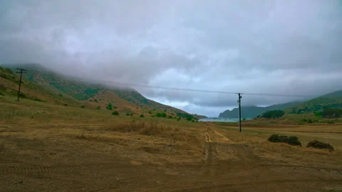 Walking through the field of dry grass and orange soil, surrounded by mountains Stock Footage 278832509