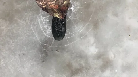 Walking through a frozen puddle of ice Stock Footage 235760603