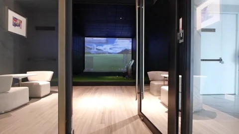 Walking Through the Golf Simulator Room decorated with the cosy armchairs Stock Footage 121810523