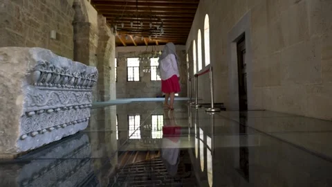 Walking through historic architecture in a quiet setting. A female tourist in a Stock Footage 305474890