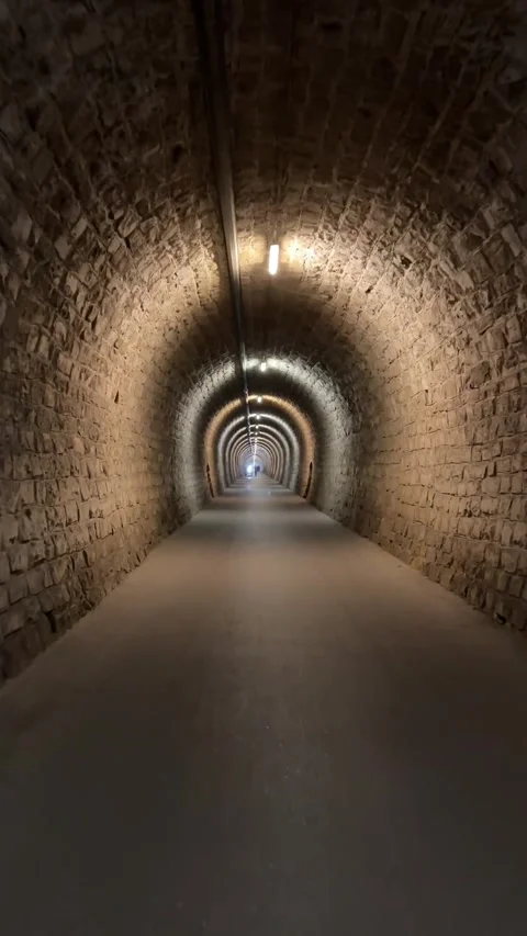 Walking Through an Illuminated Historic Stone Tunnel Видео 346186468
