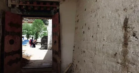 Walking through monastery doors into prayer wheels Stock Footage 93054981