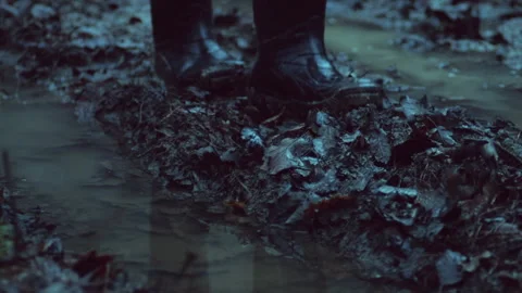 Walking through a mud in rubber boots on a forest road. High quality sound Stock Footage 243447899