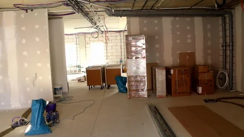 Walking through an office under construction with boxed furniture Stock Footage 112651996