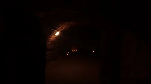 Walking through old cellars. Walk through an old underground corridor lit by Stock Footage 310524930