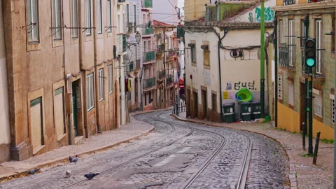 Walking through the old narrow streets of Lisbon where the traditional yellow Stock Footage 305417745
