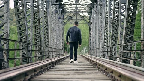 Walking through the old train tracks of the bridge Stock Footage 111979936