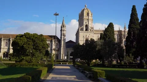 Walking through a public park towards Monastary in Lisbon at sunrise with cl Stock Footage 274531005