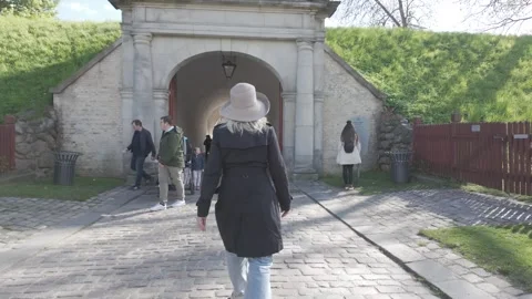 Walking through the red timber palisade toward the stone gate of Kastellet Stock Footage 341289217