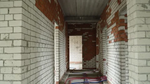 Walking through unfinished hallway of building under construction with exposed Stock Footage 345753024