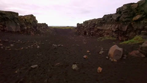 Walking through volcanic canyon with black sand in Iceland Stockbeeldmateriaal 333822480