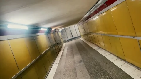 Walking Through a Yellow Tiled Underpass in a City Stock Footage 278135594