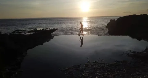 Walking on Tidepool at Sunset Bali Stock Footage 106788694