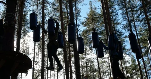Walking on tightrope at altitude between boxing pears, Climbing park "Nut" Stock Footage 88997161