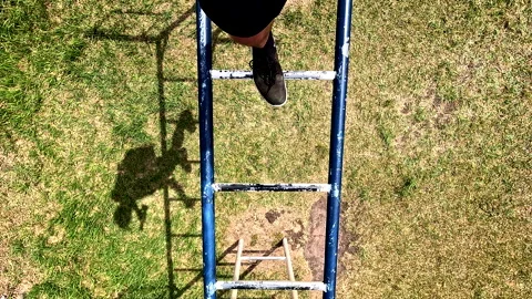 Walking on top of the bars of an old and worn metal play rack Stockbeeldmateriaal 336872185