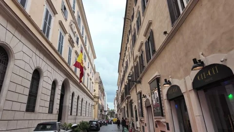 Walking tour view through historic Rome streets with Spanish flag on building Stock Footage 338009427