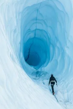 Walking toward an ice cave with deep blue ice  on the Matanuska Glacier in Al Stock Photos