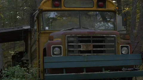 Walking towards abandoned school bus in woods to lens flare and sun Stock Footage 58121124