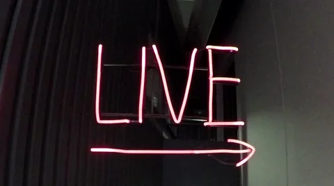 Walking towards brightly glowing red neon light sign showing the word live 4k Stock Footage 60239585