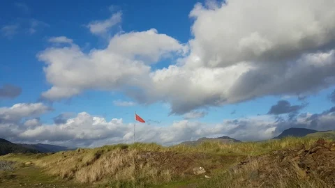 Walking towards a red flag, sand dunes and mountains Stock Footage 95814198
