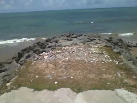 Walking towards the rocks of the beach, and showing the sea on a sunny day Stock Footage 163683140