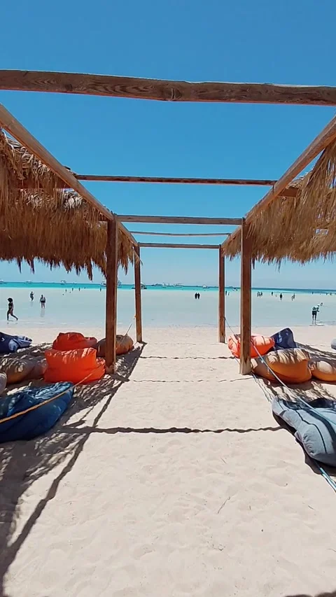 Walking towards turquoise sea under wooden canopy at Orange Bay Hurghada Egypt Stock Footage 341358222