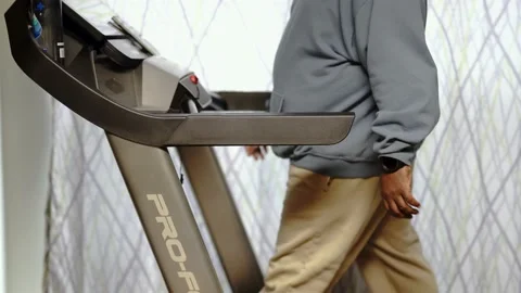 Walking on treadmill working on a cell phone black male man Stock Footage 234515540