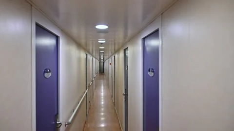 Walking trough a long corridor hallway with several doors Vídeo Stock 167434440