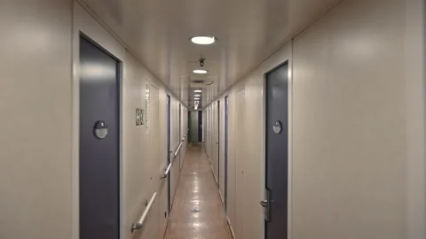 Walking trough a long corridor hallway with several doors Stock Footage 167434450