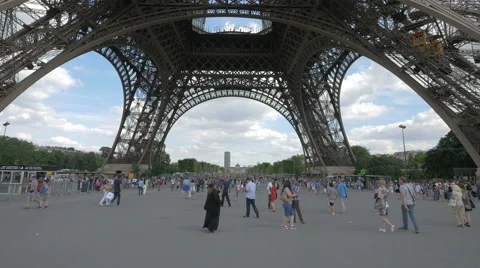 Walking under the base of Eiffel Tower in Paris Stock Footage 56859534